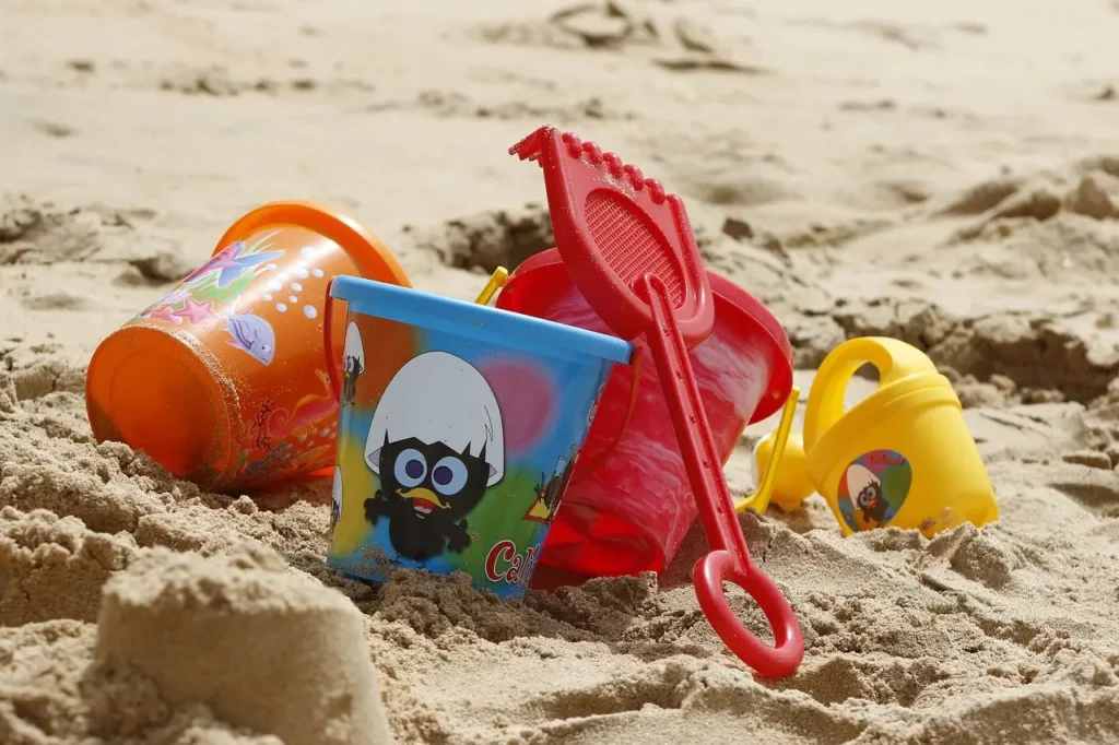  A family going to the beach with children playing with colorful sand toys.