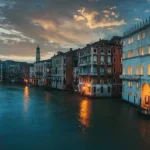 A scenic view of a canal in Venice, Italy, showcasing traditional gondolas and historic architecture, ideal for travelers seeking cultural experiences in February.