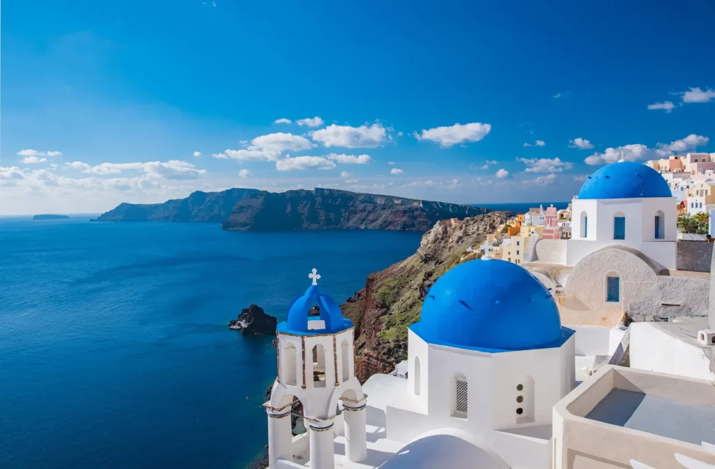 A picturesque blue-domed church in Santorini, Greece, epitomizing the charm of the island's romantic allure, making it one of the best vacation destinations for couples."