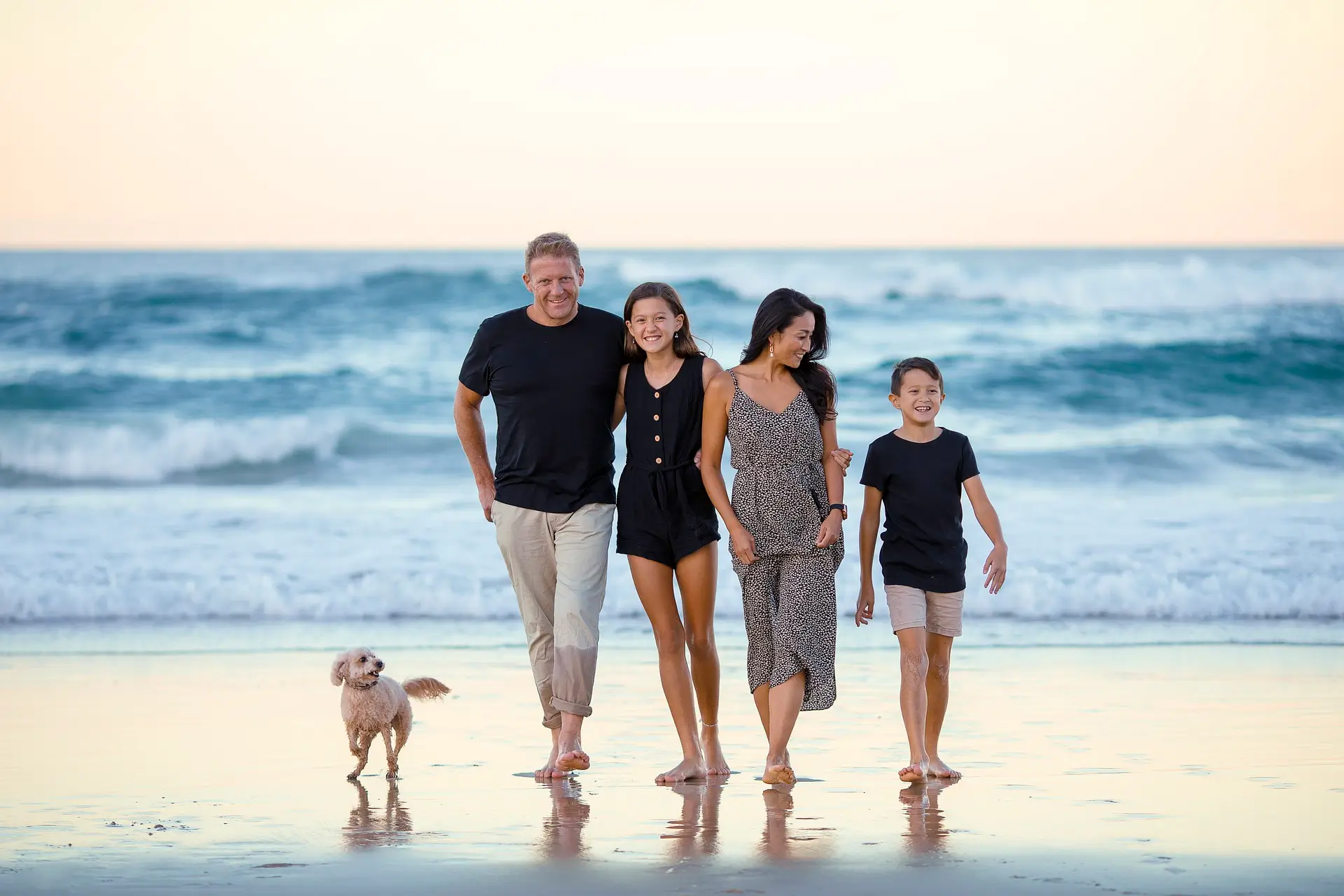 A family going to the beach, with a father, mother, and two children walking hand-in-hand, excited for a fun-filled day by the ocean.