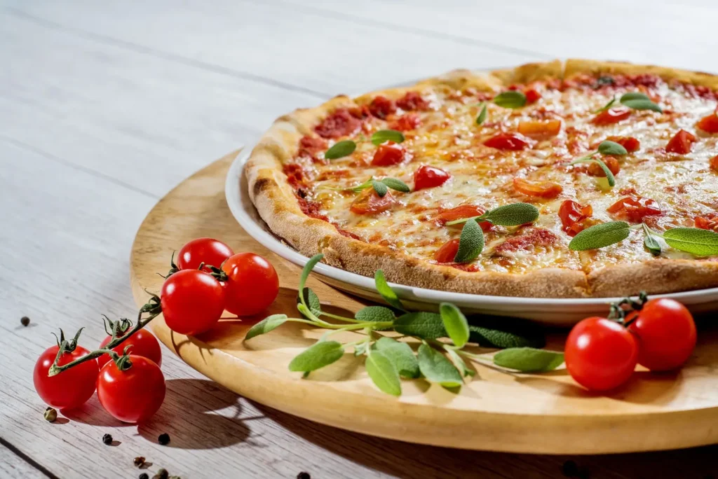 A slice of cheese pizza on a plate, representing a staple in food tours across America.