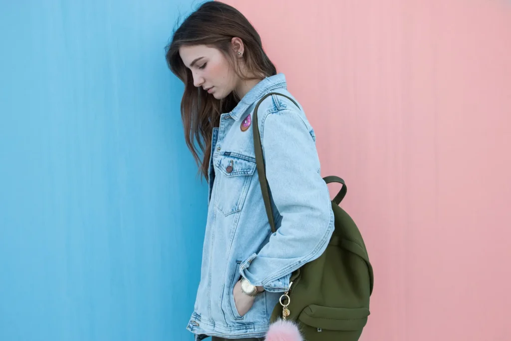 Female traveler wearing a backpack, standing against a scenic backdrop.