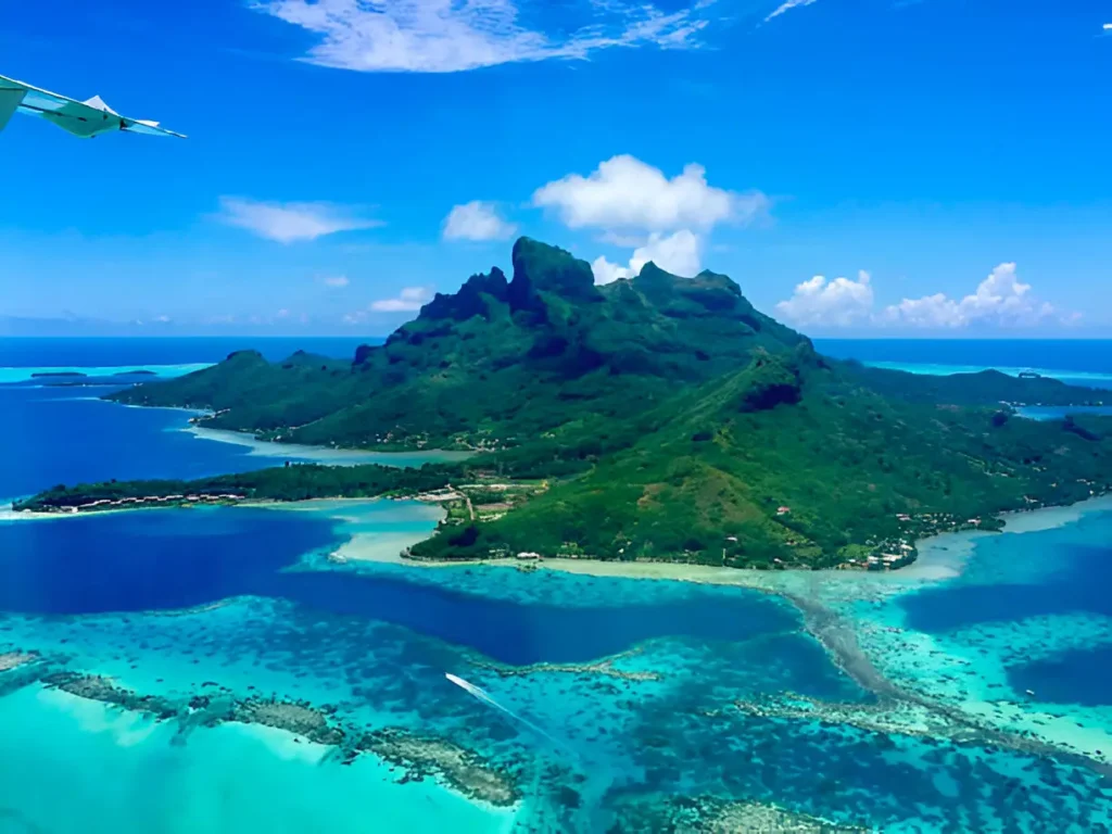  Aerial view of Bora Bora Island in French Polynesia, showcasing its turquoise lagoons and overwater bungalows, highlighting the allure of Bora Bora vs Maldives.