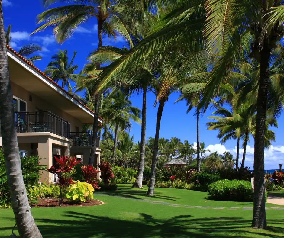 A luxurious beachfront resort in Kauai, showcasing pristine sandy shores and crystal-clear ocean waters, epitomizing the best places to stay in Kauai.