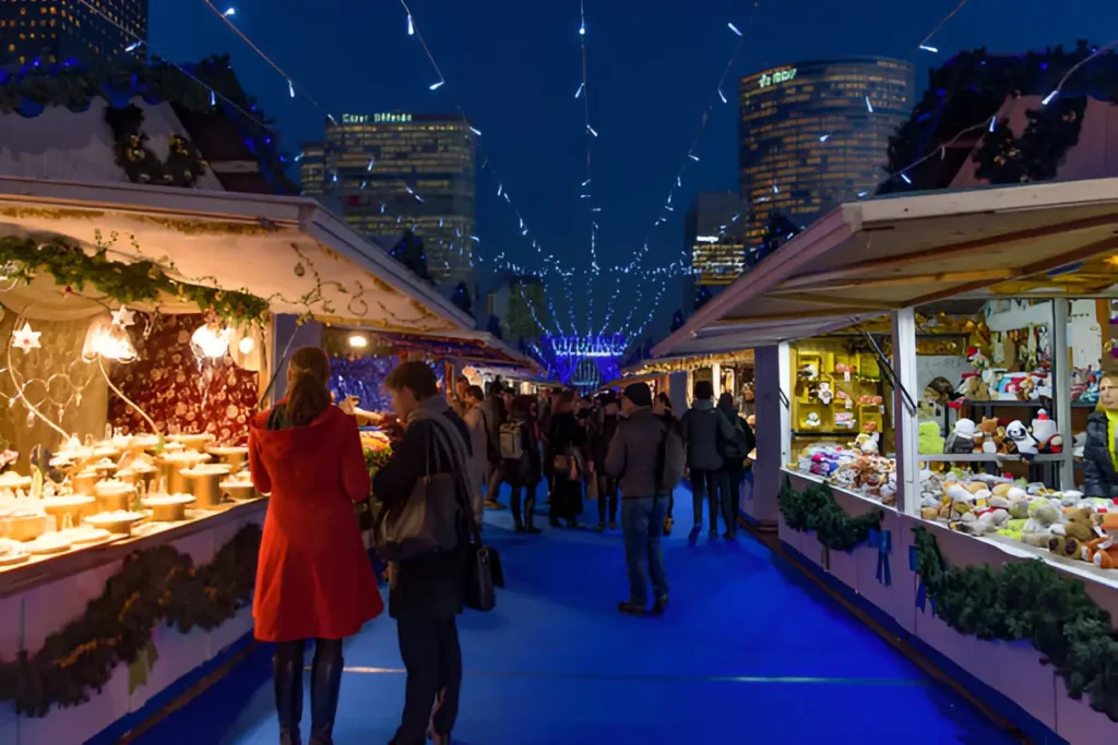 A beautiful Christmas market in Paris in December, featuring festive lights, decorated stalls, and a cozy holiday atmosphere.