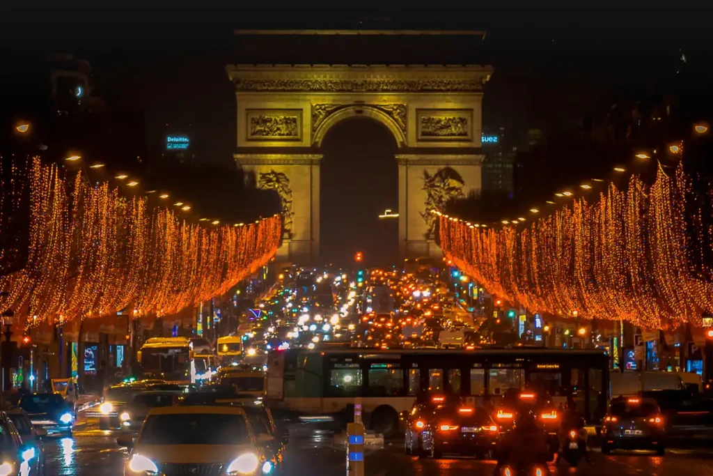 The iconic Arc de Triomphe and Champs-Élysées beautifully illuminated with festive holiday lights, capturing the enchanting atmosphere of Paris in December.