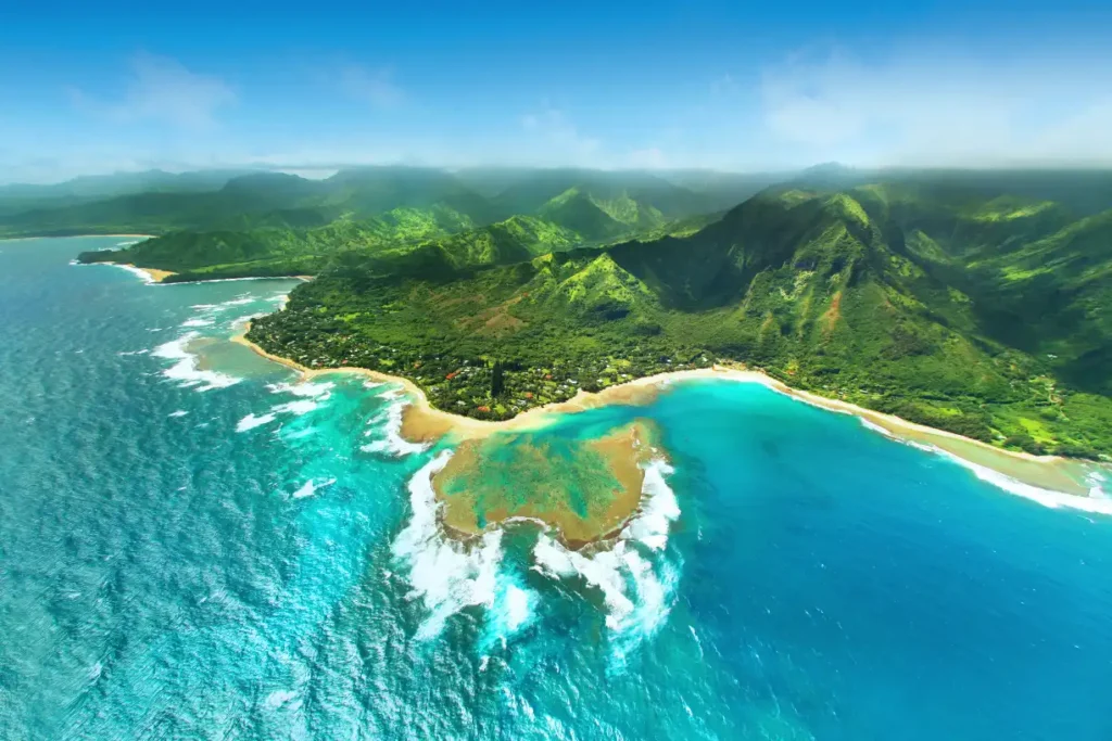 Stunning aerial view of a Hawaiian coastline with lush green mountains and turquoise waters, perfect for showcasing the ultimate Hawaii outfit.