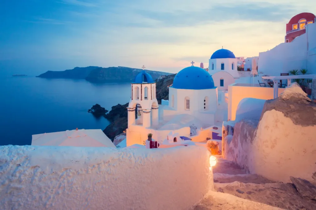 Stunning view of Santorini Greece with its iconic white-washed buildings and blue-domed churches overlooking the caldera."