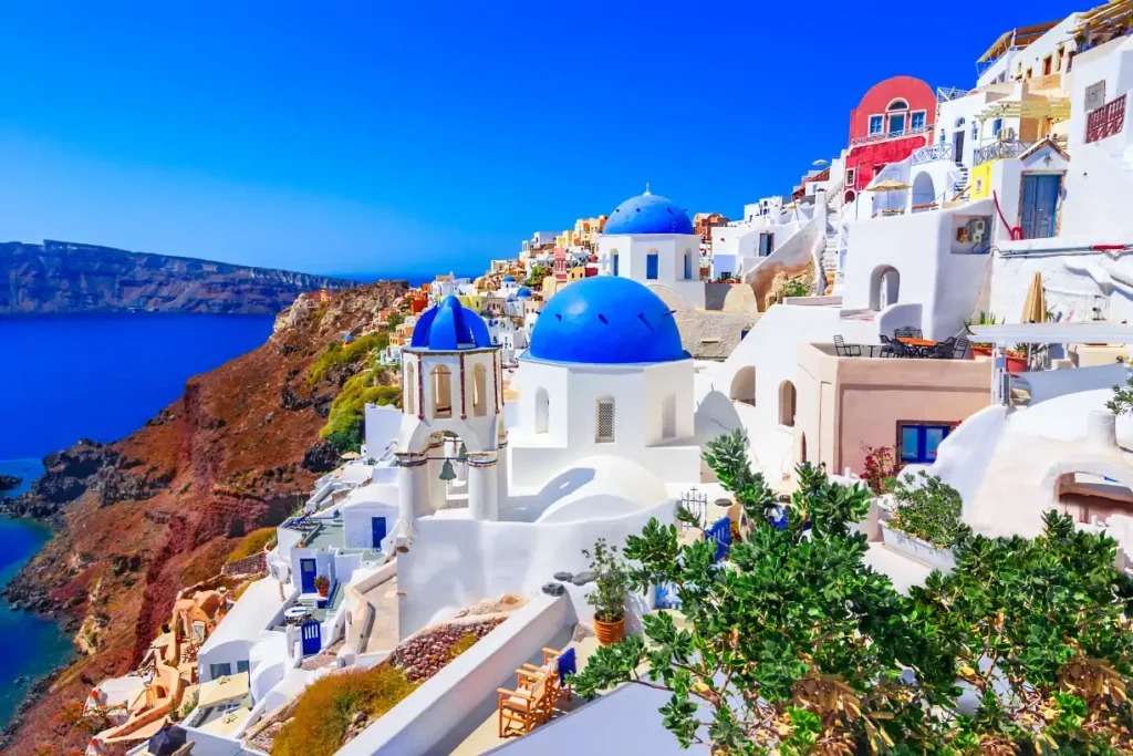 Oia, Greece with stunning views of the caldera in Santorini Greece, featuring iconic white-washed buildings and blue domes.