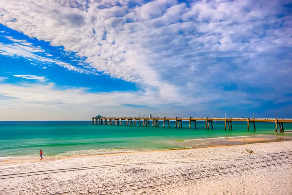 "Stunning beach walk at sunset with warm waters, perfect for enjoying the Destin water temperature during a relaxing vacation."