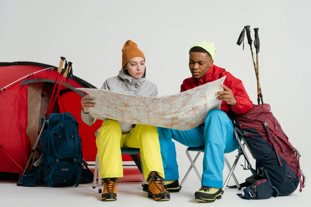 A man and a woman reading a map beside a golf bag filled with golf equipment, highlighting the best golf travel bag.