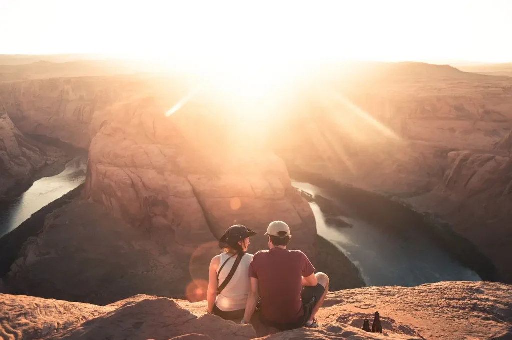  A couple embraces atop a canyon at sunrise, embodying the travel aesthetic.