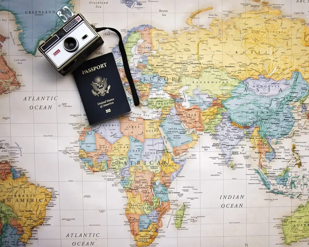  Vintage camera and U.S. passport on a world map, representing the perfect travel aesthetic.