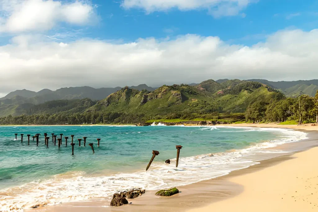 Pounders Beach in Kauai, a stunning spot for visitors looking for the best places to stay in Kauai, showcasing the scenic beauty of the island's south shore."

