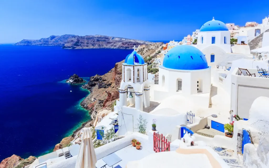 Iconic blue-domed churches overlooking the Aegean Sea in Santorini, Greece—one of the world’s most iconic luxury travel destinations.
