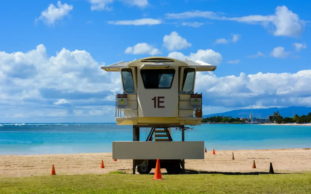 Lifeguard tower at Ala Moana Beach Park with turquoise waters and blue skies, representing one of the best beaches in Oahu.