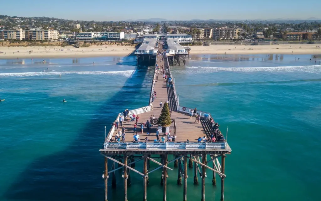 Crowds enjoying the sunny Pacific Beach Pier in San Diego, California, one of the best places to visit in August USA.