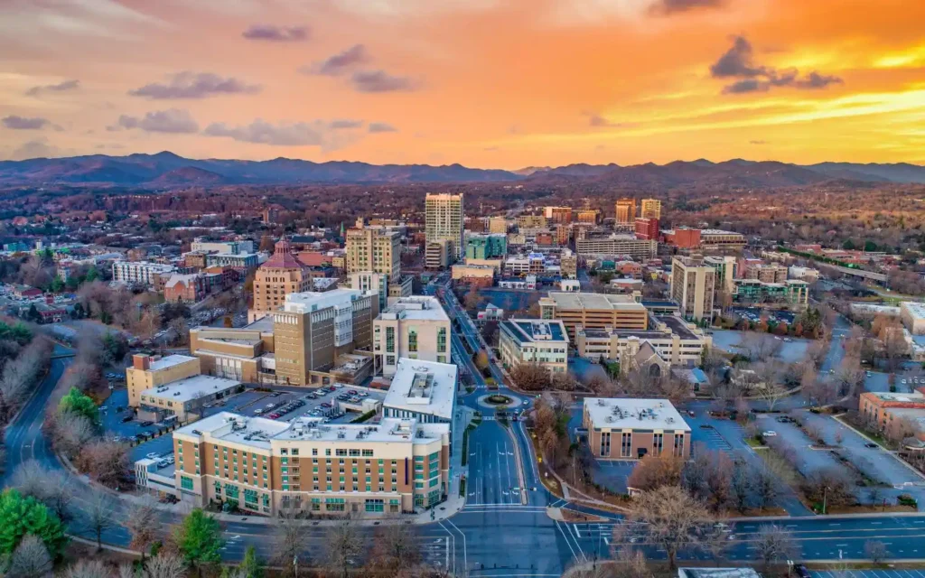 Aerial view of downtown Asheville, North Carolina at sunset – one of the best places to visit in August in the USA.